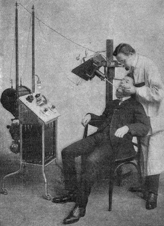 Photo of a dentist working on a patient near an X-ray machine, from the December 1909 issue of Popular Electricity